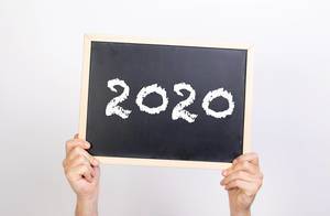 Hands holding blackboard with 2020 text