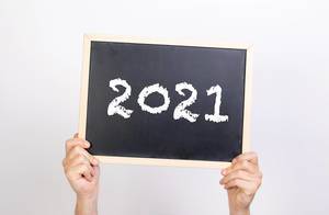 Hands holding blackboard with 2021 text