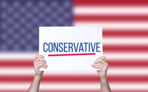 Hands holding board with Conservative text with USA flag background.jpg