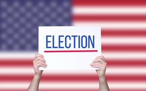 Hands holding board with Election text with USA flag background