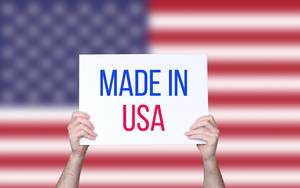 Hands holding board with Made in USA text with USA flag background.jpg