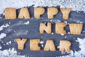 Happy New Year message, written with biscuit letters, snow