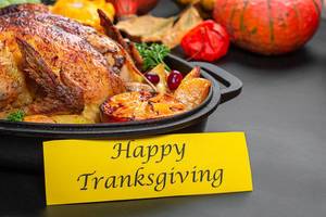Happy Thanksgiving Essen mit ganzem gebackenem Hähnchen und Kürbisdekoration im Hintergrund