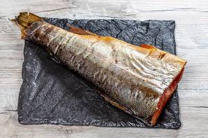 Headless smoked salmon on a black stone tray (Flip 2019)