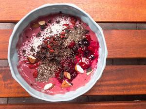 Healthy and yummy: an acai bowl topped with almonds, chia, berries, chocolate, coconut, seen from above