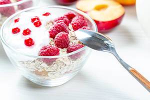 Healthy breakfast. Fresh muesli with berries in glass bowl with spoon