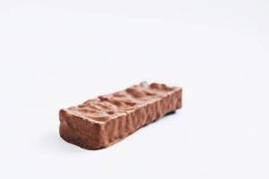 Healthy chocolate covered bar on white background