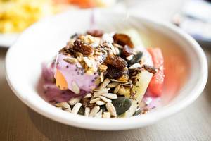 Healthy fruit bowl with yogurt, seeds, and dried berries (Flip 2019)