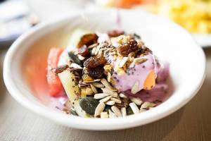 Healthy fruit bowl with yogurt, seeds, and dried berries