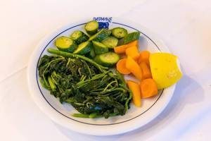 Healthy garnish for dinner, with  spinach leaves, cucumbers, cooked carrots and half a lemon