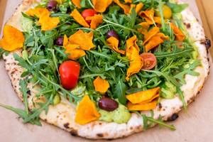 Healthy vegan Pizza with Guacamole and Salad topping