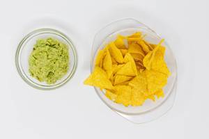 High angle shot of nachos with guacamole dip