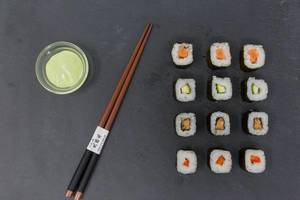 High Angle Shot of traditional japanese Chopsticks with Sushi and Wasabi Dip