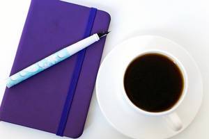 High Angle View Of The Coffee and Notebook With Pen