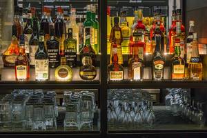 Highlighted Bar Front with many different Types of Liqueur with Glasses