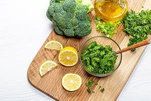 Hintergrundbild Ernährung: Sicht von oben auf grüne Sauce, frische Kräuter und eine aufgeschnittene Zitrone