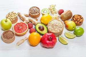 Hintergrundbild mit gesundem Essen: Frische Früchte, Nüsse, Samen und Haferflocken