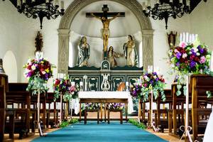 Hochzeitsdekorationen aus Blumen in einer katholischen Kirche