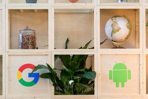 Holzregal mit Google und Android-Symbol, Globus und Brezeln im Glas