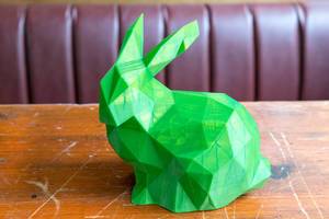 Holztisch mit einem grünen Kaninchen gedruckt von einem 3D Drucker