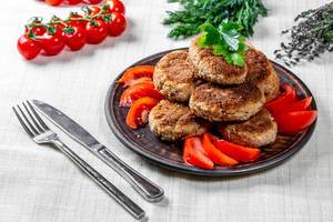 Homemade meat cutlets with Cutlery, herbs and tomatoes