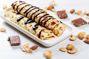 Homemade pancakes with chocolate topping and nuts