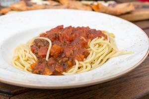 Homemade Spaghetti Bolognese in a pointed white plate