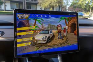 Homescreen of Beach Buggy Racing 2 for two players on the Tesla Model 3 Display, in front of a Supercharger station