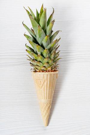 Ice cream cone with pineapple leaves on white background. Fruit and candy concept (Flip 2019)
