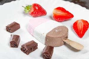 Ice cream with pieces of chocolate and strawberries on a white plate. Summer dessert concept