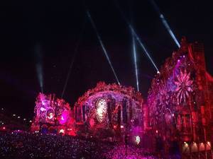 Illuminated purple main stage and pitch black sky at electronic music festival Tomorrowland