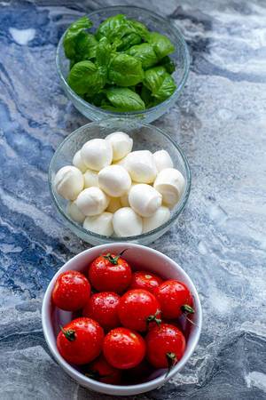 Ingredients for making Caprese salad on a grey background