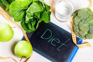Inscription diet with measuring tape and green vegetables and fruits