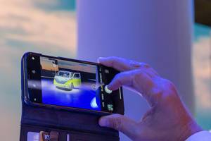 Instagramfotos von der IAA: Mann macht ein Handybild vom Concept-Car & Elektrobulli ID.BUZZ im Retrolook
