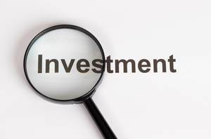 Investment text under magnifying glass