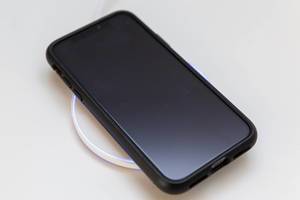 Iphone wird durch die universell einsetzbare, stylische Limxems Qi Induktionsladestation aufgeladen