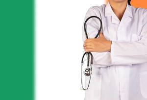 Irisches Gesundheitssystem symbolisiert durch die Nationalflagge und eine Ärztin mit Stethoskop in der Hand