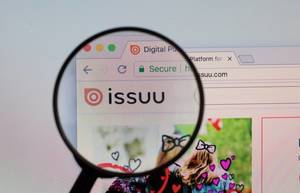 Issuu-Logo am PC-Monitor, durch eine Lupe fotografiert