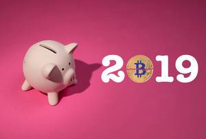 Jahreszahl 2019 mit Bitcoinmünze, auf pinker Hintergrund, neben einem rosa Sparschwein