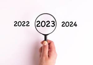 Jahreszahl 2023 auf weißer Oberfläche unter einer Lupe dargestellt