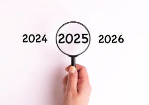 Jahreszahl 2025 auf weißer Oberfläche unter einer Lupe dargestellt