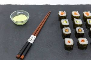 Japanese Chop Sticks with Sushi and Wasabi on black plate