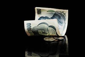 Japanische Yen spiegeln sich auf schwarzer Oberfläche