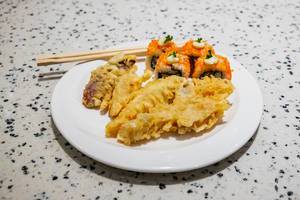 Japanisches Tempura und Maki-Sushi, mit Esstäbchen auf einem weißen Teller