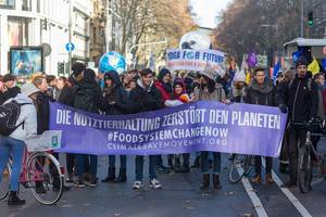 Jugendliche halten ein Banner mit "Die Nutztierhaltung zerstört den Planeten " hoch