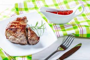 Juicy steak cooked on the grill with tomato sauce