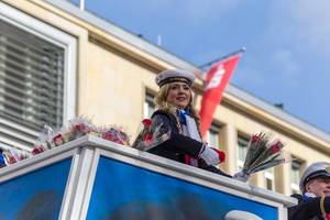 Junge Frau vom Tanzkorps KG Mullemer Junge wirft Publikum Blumen zu - Kölner Karneval 2018