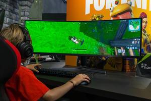 Junge spielt Fortnite auf breitem curved-Bildschirm von Samsung und mt RTX