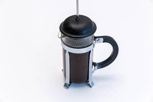 Kaffee kochen mit einem French Press Kaffeebereiter, gefüllt mit heißem Wasser und Kaffeepulver