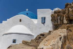 Kalkstein-Kloster Agios Ioannis Detis mit blauer Kuppel, im Umweltpark von Paros auf Griechenland, an einer felsigen Küste an der Ägäis gebaut